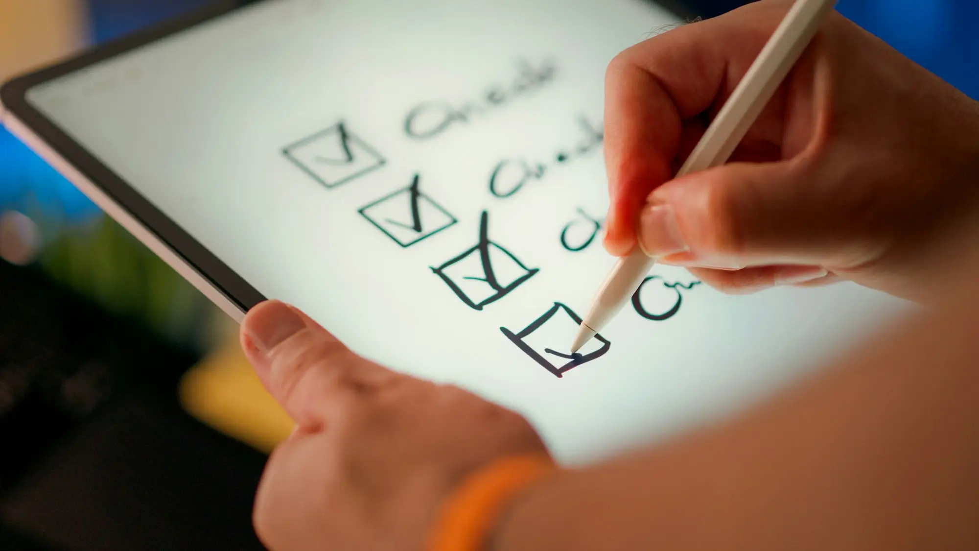 Hand holding a pen ticking boxes on a printed checklist.